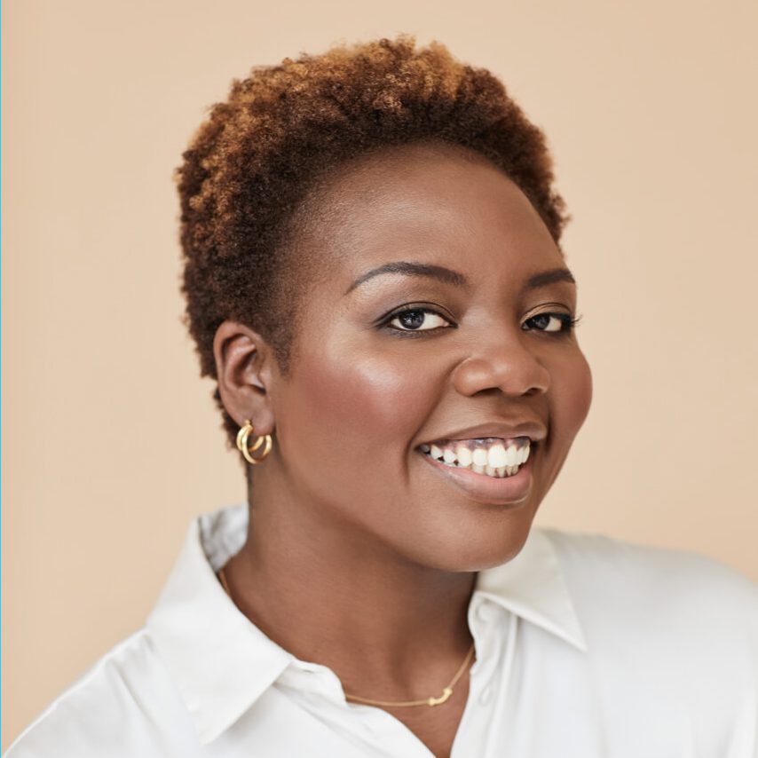 Smiling woman with short curly hair and earrings.