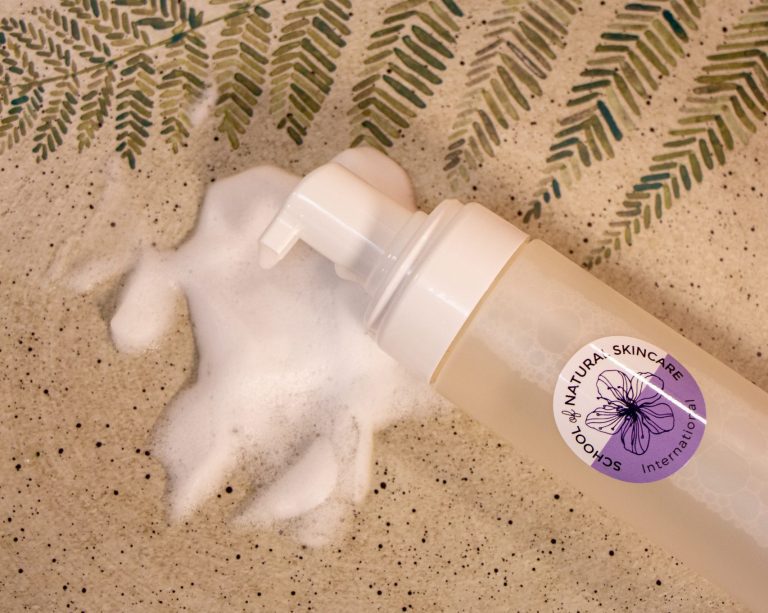 Foaming skincare product with botanical design on label.